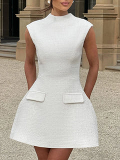 White textured mini dress with round neck and cap sleeves, flared skirt, flap pockets