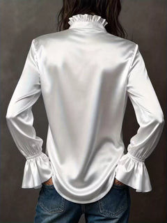 White button-up blouse from back with high ruffled collar and flounce sleeve cuffs