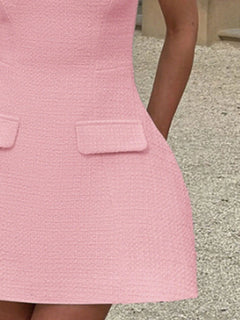 Pink mini dress close-up, front flap pockets on textured fabric