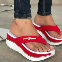 Red platform toe-post sandals with gold logo bar and white curved stripe on the upper.