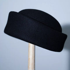 Black wool pillbox hat, side view with structured flat brim