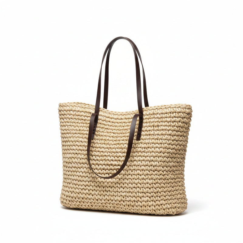 Woven straw tote bag with brown leather handles, woven straw open-top design.