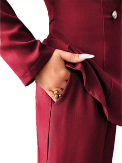 Burgundy blazer and pants set detail: one-button closure and matching fabric drape.