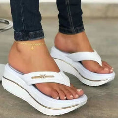 White platform toe-post sandals with gold trim and logo bar across the toe strap.
