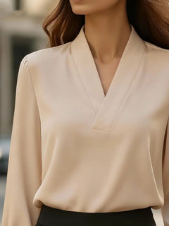 Satin V-neck long-sleeve blouse in beige with V-neckline and tailored seam details.