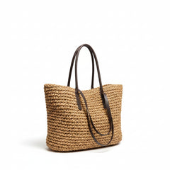 Woven straw tote bag, tan woven straw with brown leather handles and top opening.