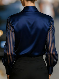 Back view of navy blue collared blouse with sheer striped sleeves