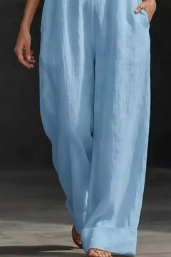 Light blue wide-leg jumpsuit with halter V-neck and flowing, wide trouser legs