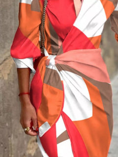 Red and orange geometric printed waist-tie shirt dress with collar and 3/4 sleeves.