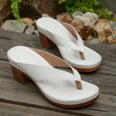 White toe-post block-heel sandals with perforated insole, curved thong strap, and wood-look heel.