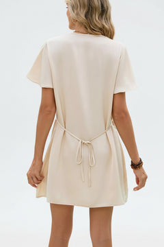 Cream mini dress back view with flutter sleeves and waist tie straps