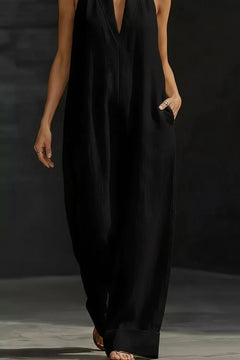 Black sleeveless wide-leg halter jumpsuit with deep V neckline and relaxed fit
