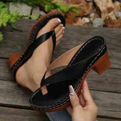 Black toe-post block-heel sandals with beige understrap and curved open-toe design.