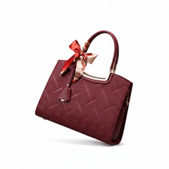 Wine red embossed leather top handle handbag with bow accent and side zipper pocket