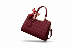 Wine red embossed leather tote handbag with top handle, bow detail, and shoulder strap