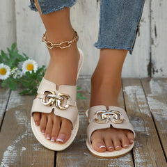 White open-toe sandals with gold-tone buckle detail and gold chain ankle strap.