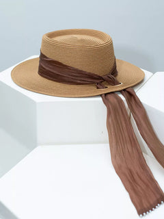 Ribbon-accent straw sun hat in brown with wide brim and long tied ribbon