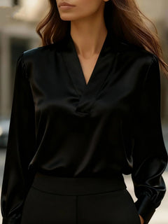 Satin V-neck long-sleeve blouse in black with gathered puff sleeves and elastic cuffs.