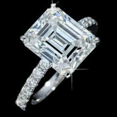  ring with a large emerald-cut center stone on a black background