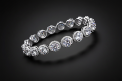 Silver bracelet with clear gemstones on a light grey background