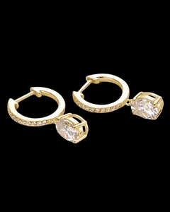 Gold hoop earrings with clear gemstones on a black background