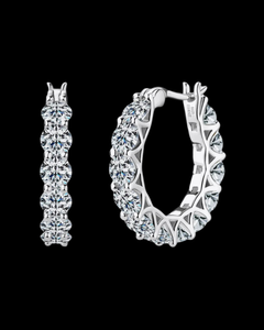 Pair of silver hoop earrings on a black background