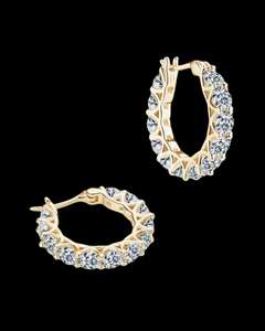 Gold hoop earrings with clear gemstones on a black background