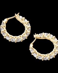 Gold hoop earrings with clear gemstones on a black background