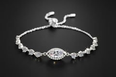 Silver bracelet with clear gemstones on a light grey background