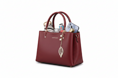 Red leather top-handle handbag, open top with phone and card holder, leaf charm