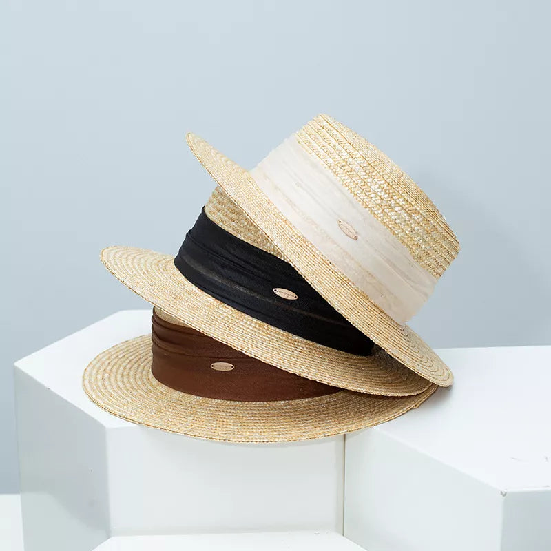 Straw boater hat with black ribbon band and beige woven brim