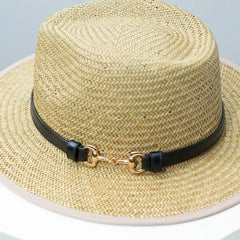 Straw fedora hat close-up with woven texture and dark decorative band