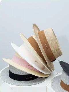Set of straw boater hats with ribbon bands in beige, pink, black, and gray