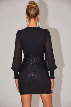 Back view of black sequin mini dress with sheer long sleeves and smocked waist