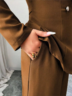 Brown blazer and pants set close-up, one-button waist detail and tailored trouser seams.