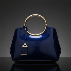 Indigo glossy handbag with ring handle and hanging keychain charm detail
