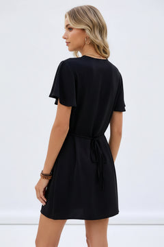 Black mini dress back view with flutter sleeves and waist tie detail