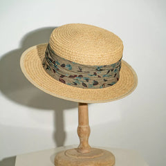Straw boater hat with printed band, beige crown and brim, green patterned band