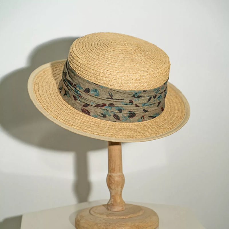 Straw boater hat with printed band, beige crown and brim, green patterned band