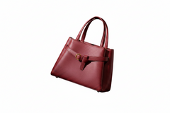 Burgundy leather top-handle handbag, side view with front buckle strap and tapered base