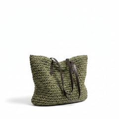Woven straw tote bag, green woven straw with dark brown leather handles, open top.