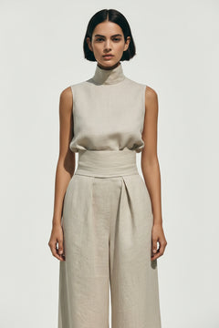 Ivory sleeveless turtleneck top with draped waist and wide-leg pants
