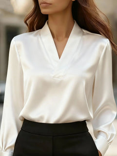 Satin V-neck long-sleeve blouse in white with gathered puff sleeves and elastic cuffs.